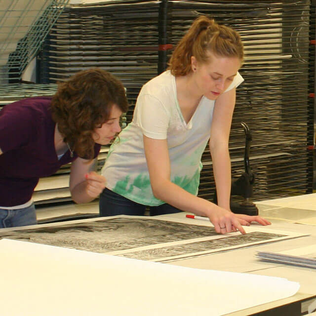 Students and faculty examining the edition of Rudy Pozzatti prints.