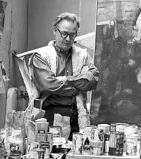 Burford in studio surrounded by painting and supplies.