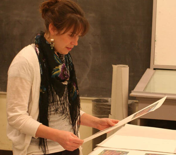 Artist Lisa Lofgren studies her prints at the 2011 Normal Editions Workshop.