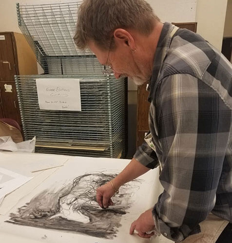 Mark E. Ritchie drawing in the studio.