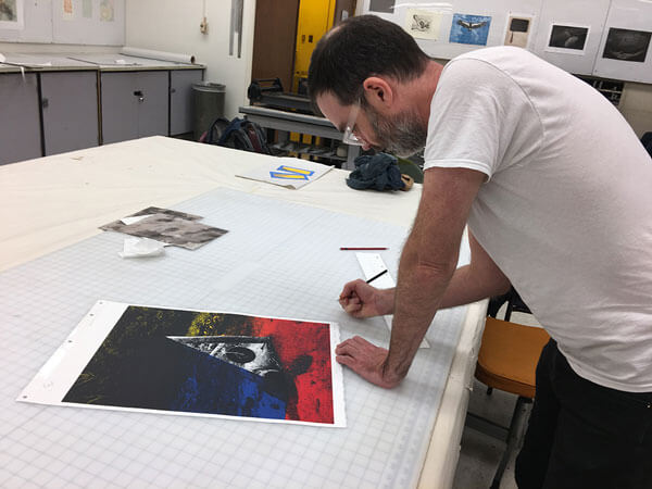 Artist Reuben Lorch-Miller signs his print at the 2017 Normal Editions Workshop.