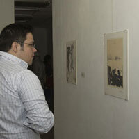 Patron views a print in a gallery.